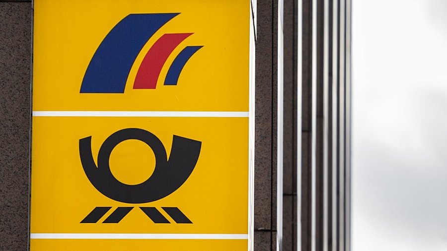 Schild mit Postbank-, Deutsche-Post und DHL-Logo an Hauswand