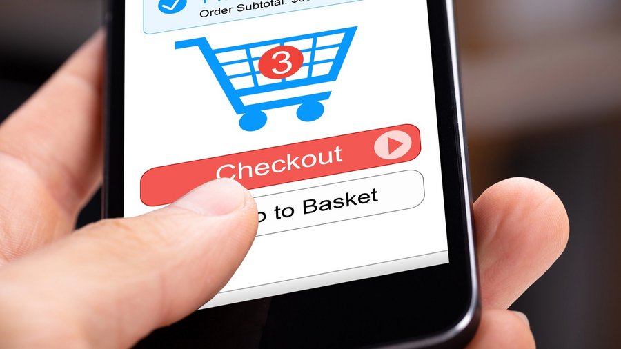 Person hält Smartphone mit Warenkorbsymbol, das zeigt, dass 3 Sachen im Warenkorb liegen, kurz vor dem Check-out