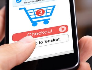 Person hält Smartphone mit Warenkorbsymbol, das zeigt, dass 3 Sachen im Warenkorb liegen, kurz vor dem Check-out