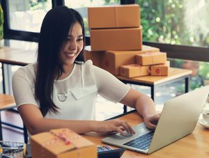 Frau am PC mit Paketen