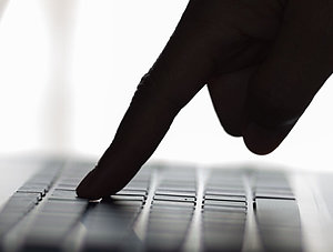 Hand &uuml;ber Laptop Tastatur im Schatten