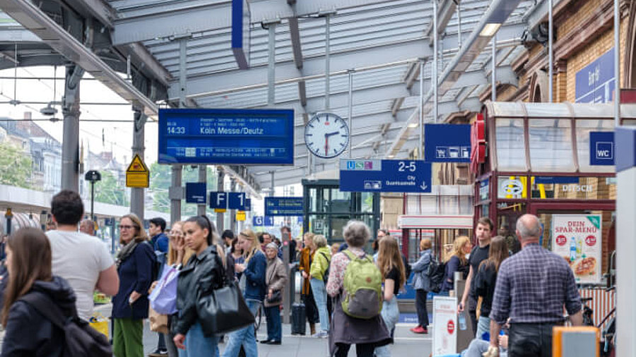 Leute am Bahnhof warten am Gleis