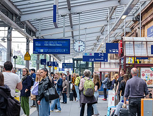 Leute am Bahnhof warten am Gleis