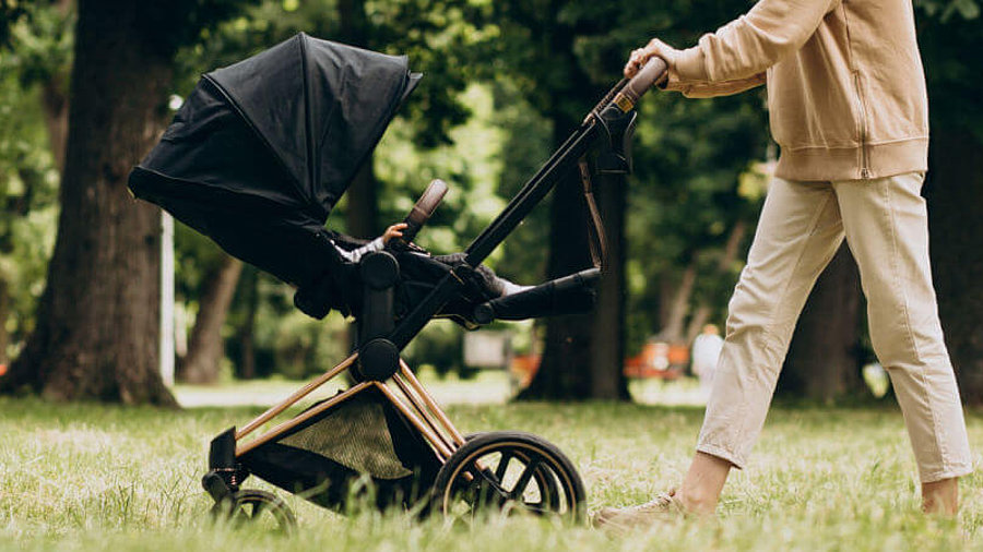 Frau schiebt Kinderwagen