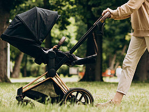 Frau schiebt Kinderwagen