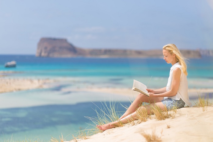 Lady liest ein Buch am Meer