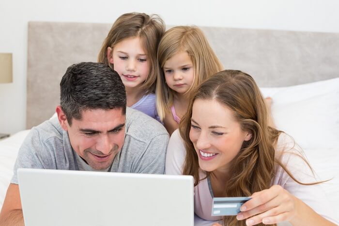 Familie Online-Shopping auf Bett