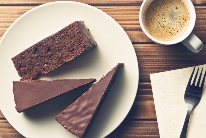 Schokoladenkuchen auf Teller, dazu eine Tasse Kaffee