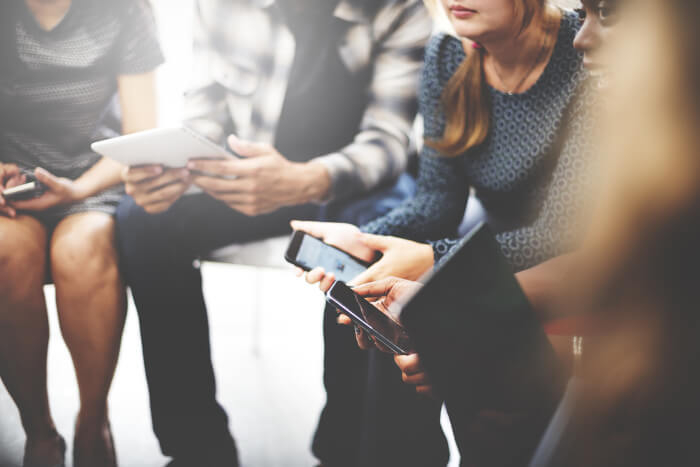 Junge Menschen mit Tablets und Smartphones