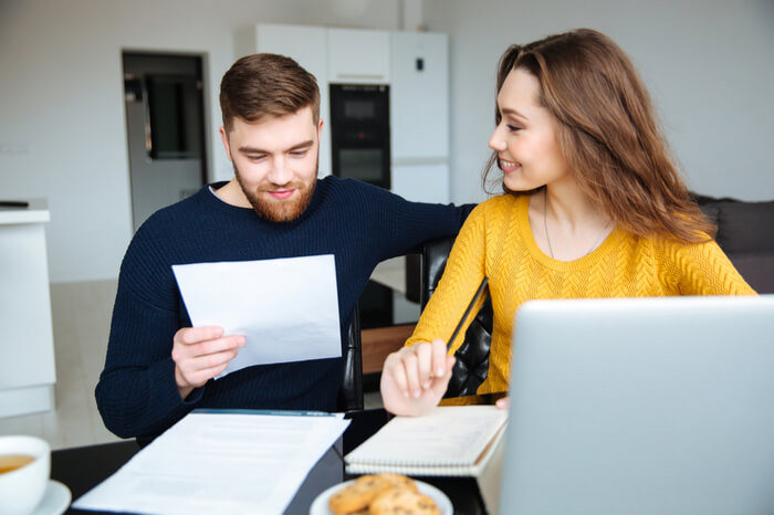 Mann und Frau mit Rechnung am Laptop