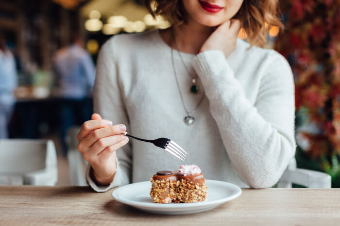 Frau vor Kuchenstück in Restaurant