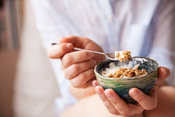 Frau mit Müsli-Schüssel in den Händen