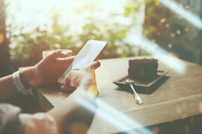 Person mit Smartphone im Café