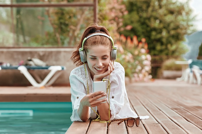 Lady hört Musik am Pool