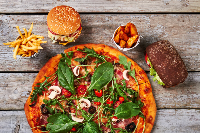 Pizza, Burger und anderes Fast Food auf einem Tisch 